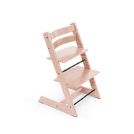 Pink adjustable wooden high chair with black footrest. 
