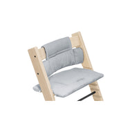 Wooden high chair featuring a soft, gray gingham seat cushion and backrest for comfortable mealtimes. 
