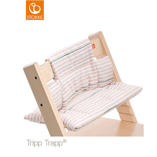 Pink and white striped cushion set on a Stokke Tripp Trapp high chair. 
