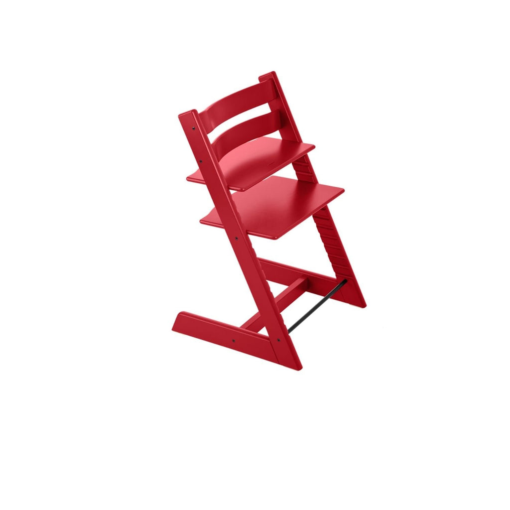 Red wooden high chair with adjustable seat and footrest on white background. 
